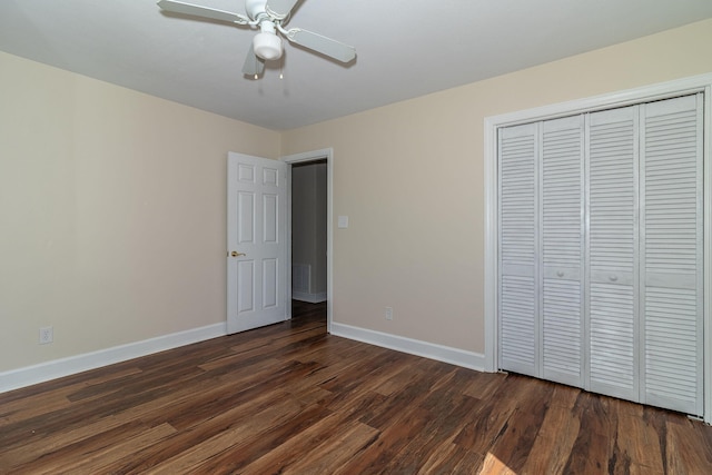 unfurnished bedroom featuring dark wood-type flooring, baseboards, a closet, and ceiling fan