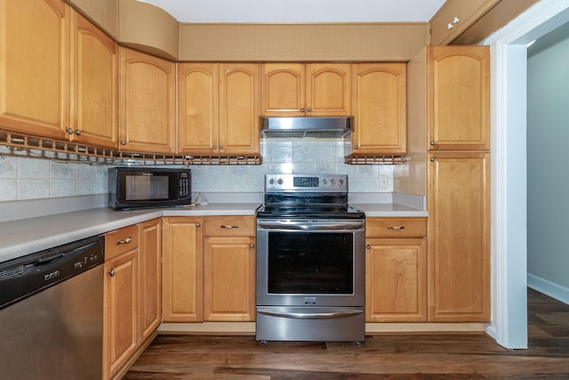 kitchen featuring tasteful backsplash, dark wood-type flooring, under cabinet range hood, light countertops, and stainless steel appliances