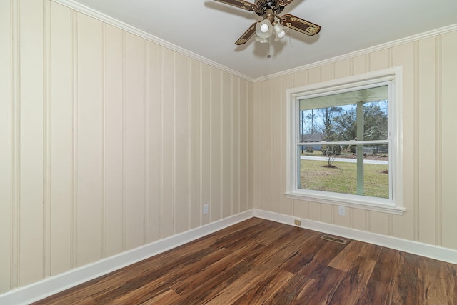 unfurnished room with visible vents, ceiling fan, baseboards, ornamental molding, and dark wood-style flooring