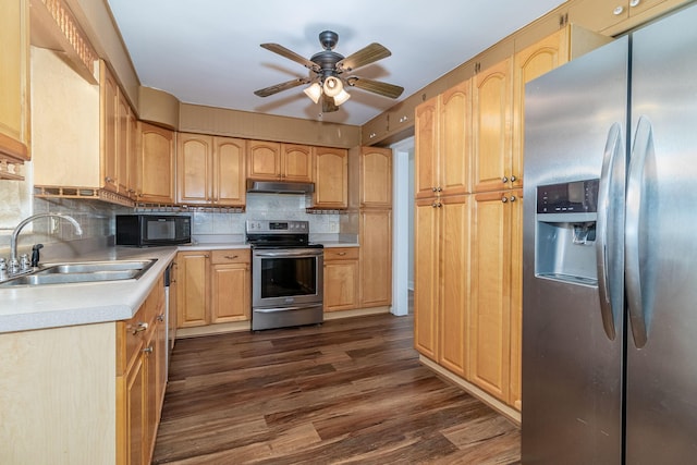 kitchen featuring dark wood-style floors, a ceiling fan, a sink, stainless steel appliances, and under cabinet range hood