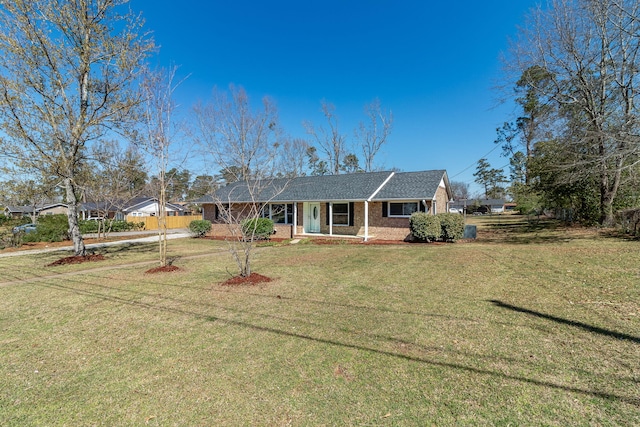 ranch-style home with brick siding, a porch, and a front lawn