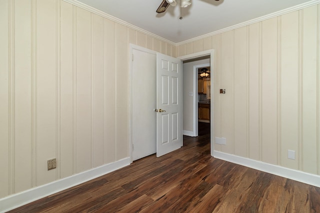 spare room featuring dark wood-style floors, baseboards, ceiling fan, and ornamental molding