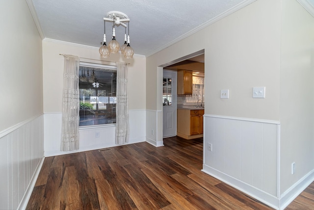 unfurnished dining area featuring wainscoting and dark wood-style flooring