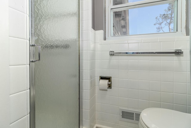 full bathroom featuring visible vents, a shower stall, toilet, and tile walls