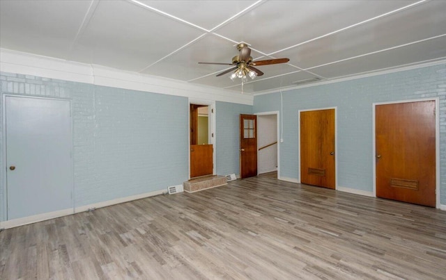 418 Kemp Dr, Augusta, GA 30909 - unfurnished bedroom featuring wood finished floors, brick wall, attic access, and a ceiling fan