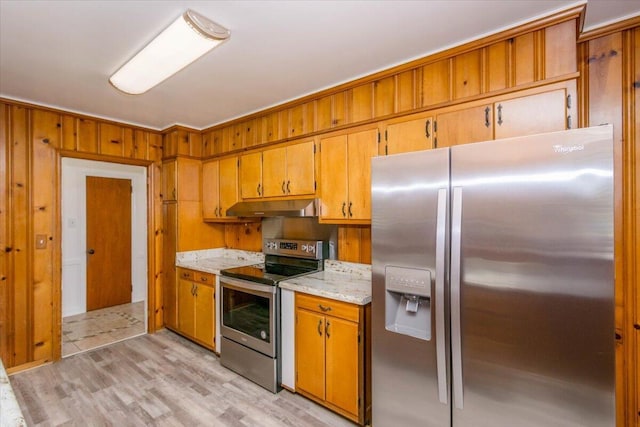 418 Kemp Dr, Augusta, GA 30909 - kitchen with appliances with stainless steel finishes, under cabinet range hood, light wood-style floors, brown cabinetry, and wood walls