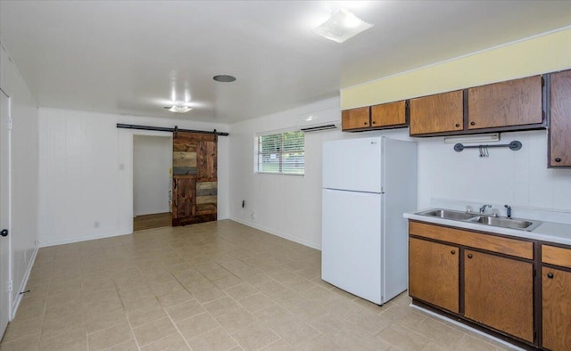 418 Kemp Dr, Augusta, GA 30909 - kitchen featuring freestanding refrigerator, a barn door, light countertops, and brown cabinetry