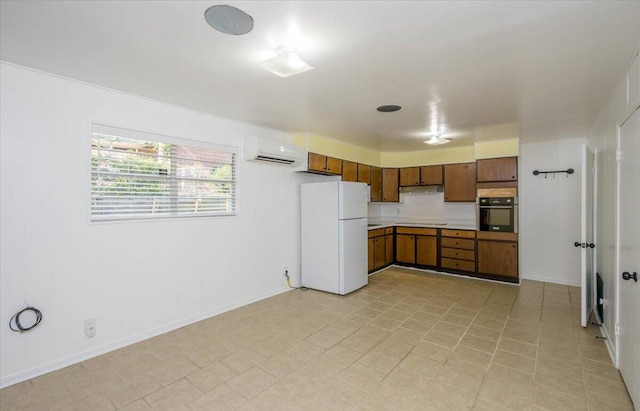 418 Kemp Dr, Augusta, GA 30909 - kitchen with freestanding refrigerator, oven, a wall mounted AC, light countertops, and brown cabinetry