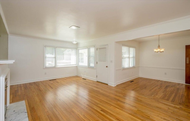 418 Kemp Dr, Augusta, GA 30909 - unfurnished living room featuring a chandelier, ornamental molding, light wood-style flooring, and plenty of natural light