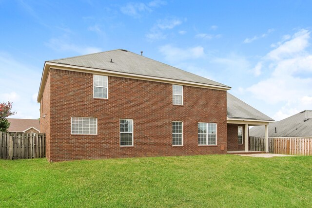 back of property with a lawn and a patio area