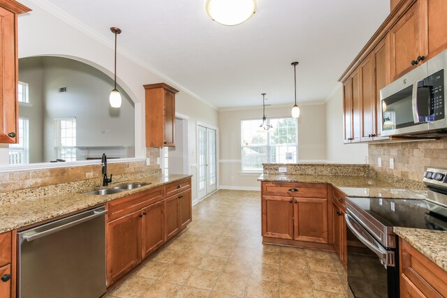 kitchen featuring kitchen peninsula, stainless steel appliances, hanging light fixtures, and sink