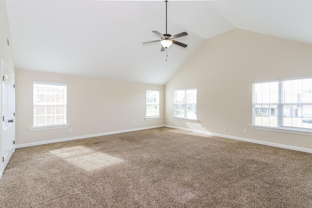 empty room with ceiling fan, plenty of natural light, carpet, and high vaulted ceiling