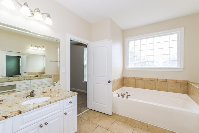 bathroom with tile patterned floors, vanity, and a washtub