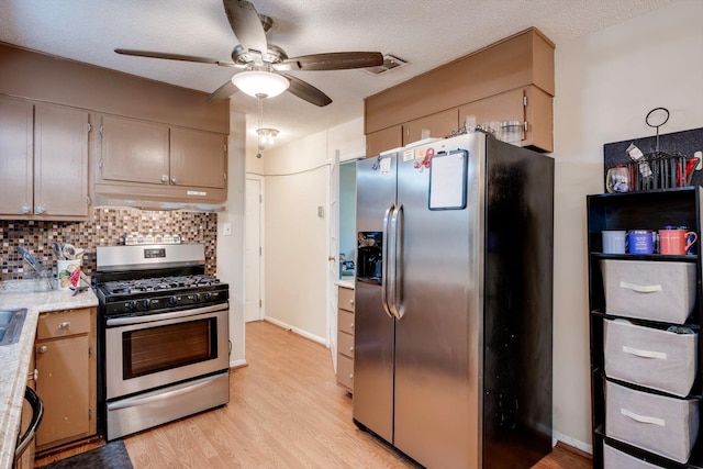 431 Edgar Cir, Thomson, GA 30824 - kitchen featuring stainless steel appliances, under cabinet range hood, light countertops, light wood-style floors, and a ceiling fan