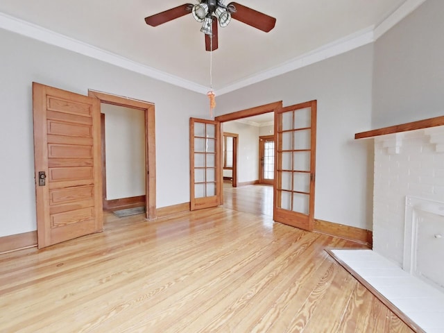 unfurnished living room with french doors, baseboards, crown molding, and light wood-style floors