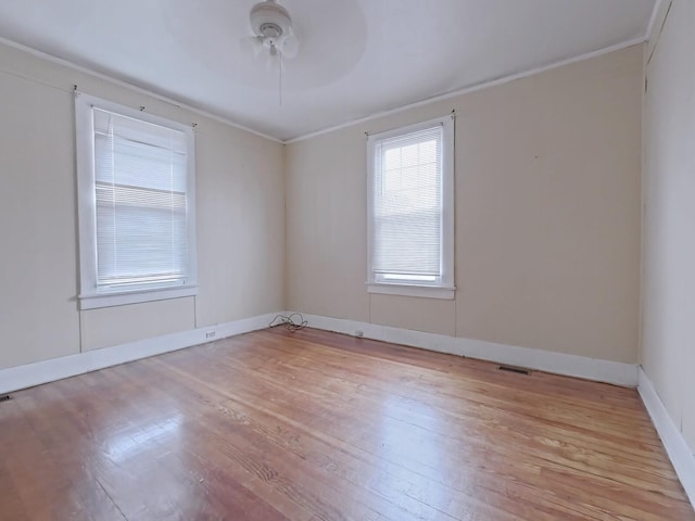 unfurnished room with baseboards, ceiling fan, crown molding, and light wood finished floors