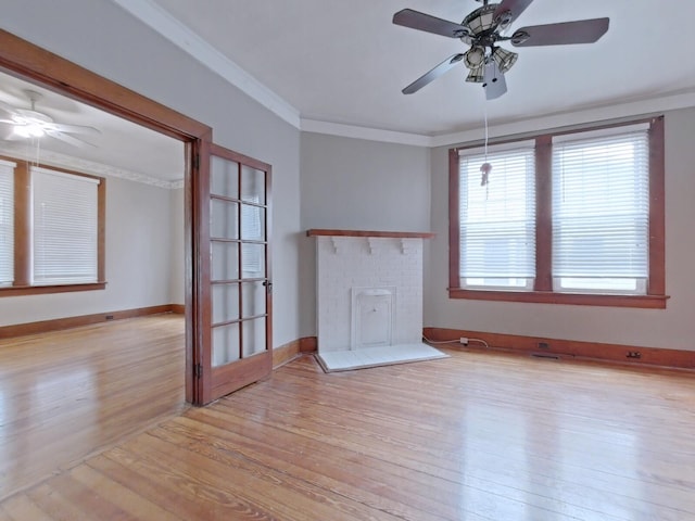 unfurnished living room featuring a fireplace, crown molding, light wood-style floors, and ceiling fan