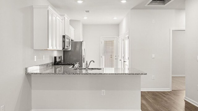 kitchen with white cabinets, light stone counters, sink, and appliances with stainless steel finishes