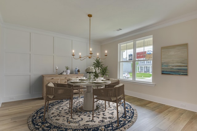 dining room with crown molding, a chandelier, and light wood-type flooring