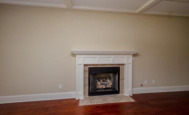 room details with crown molding, wood finished floors, baseboards, and a fireplace