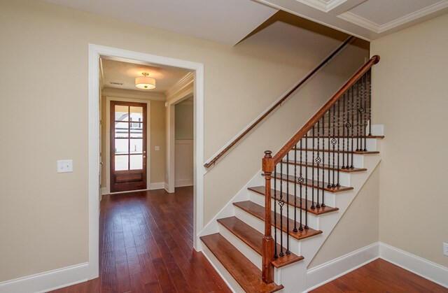 stairs featuring baseboards, ornamental molding, and hardwood / wood-style flooring