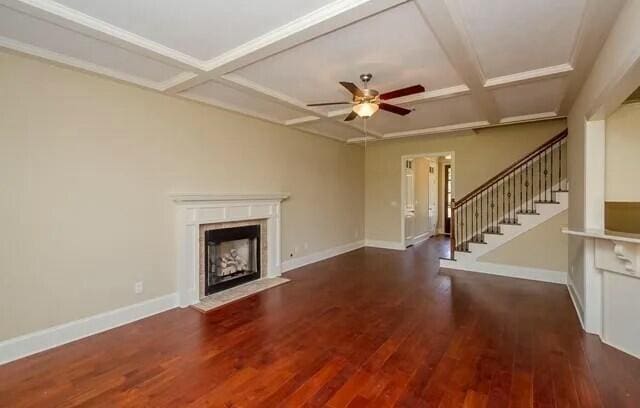 unfurnished living room featuring coffered ceiling, baseboards, ceiling fan, wood finished floors, and a fireplace