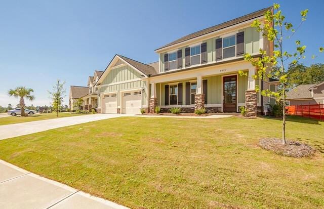 craftsman inspired home featuring covered porch, driveway, a garage, a front lawn, and board and batten siding