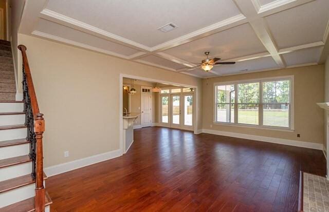 unfurnished living room with baseboards, stairs, coffered ceiling, and dark wood-type flooring
