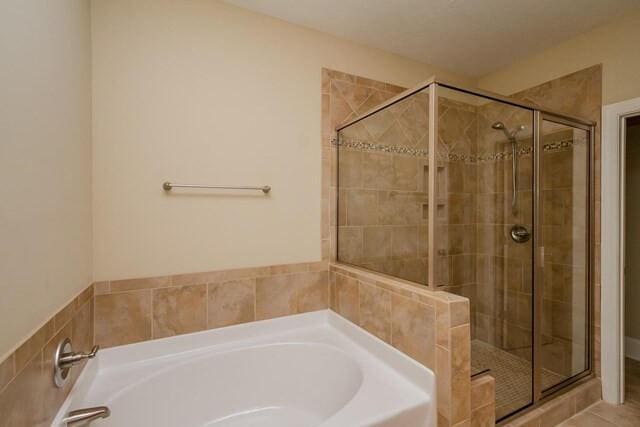 full bath with a garden tub and a shower stall