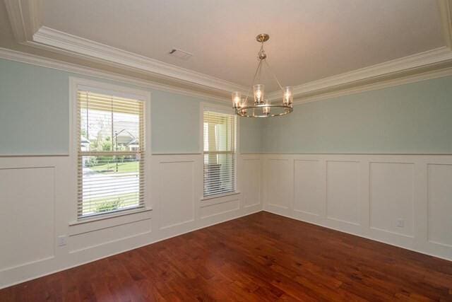 empty room with dark wood-style flooring, an inviting chandelier, and crown molding