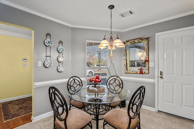 tiled dining area featuring crown molding and an inviting chandelier