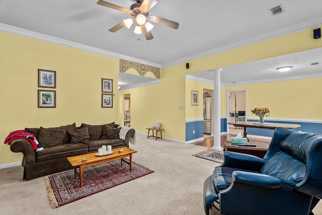 carpeted living room featuring decorative columns, ceiling fan, and ornamental molding