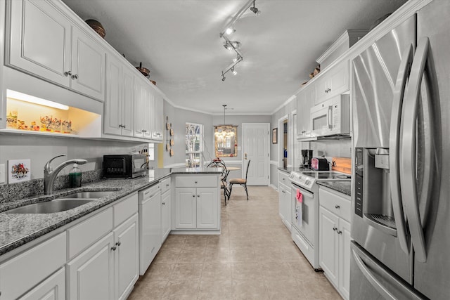 kitchen featuring sink, crown molding, pendant lighting, white cabinets, and appliances with stainless steel finishes