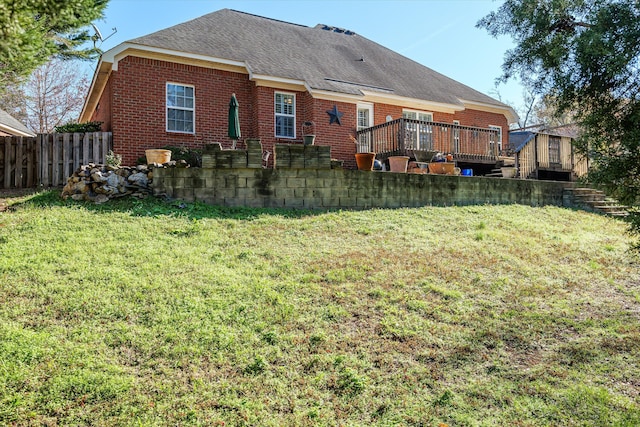 rear view of house featuring a yard and a wooden deck