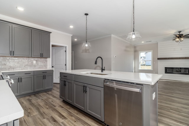 kitchen with dishwasher, sink, pendant lighting, gray cabinets, and a center island with sink