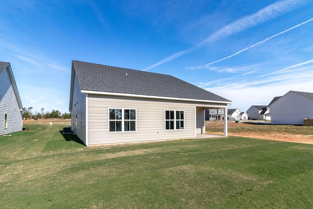 rear view of property featuring a yard and central AC unit