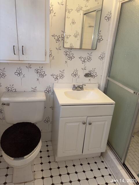 bathroom with walk in shower, vanity, and toilet