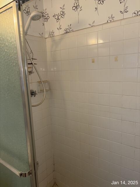 bathroom featuring a shower with shower door