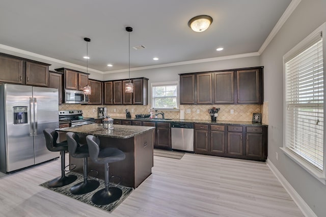 251 Wentworth Pl, Grovetown, GA 30813 - kitchen featuring appliances with stainless steel finishes, dark brown cabinets, a sink, dark stone countertops, and ornamental molding