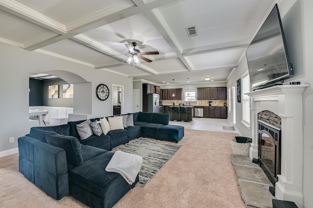 251 Wentworth Pl, Grovetown, GA 30813 - living area with coffered ceiling, a ceiling fan, light colored carpet, a glass covered fireplace, and arched walkways