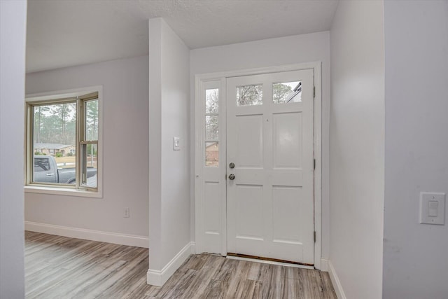 foyer with light hardwood / wood-style floors and a textured ceiling