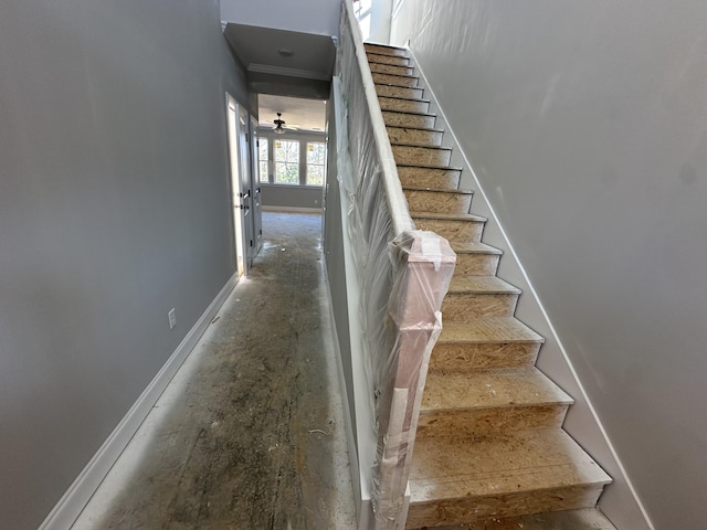 stairway featuring ceiling fan