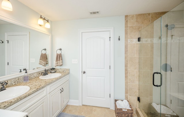 bathroom with tile patterned flooring, vanity, and walk in shower