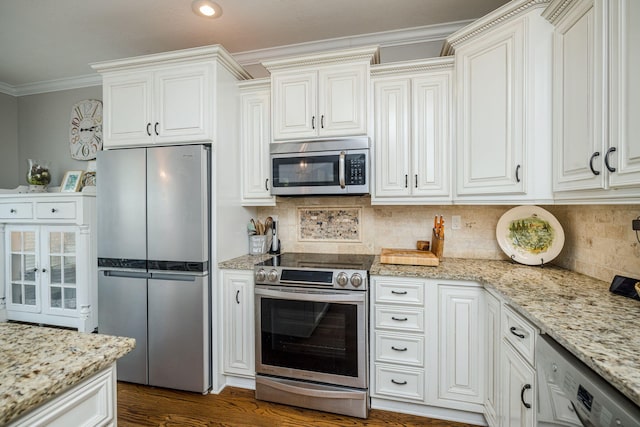 kitchen with tasteful backsplash, white cabinetry, stainless steel appliances, and ornamental molding