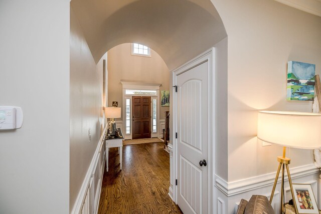 corridor featuring dark wood-type flooring and vaulted ceiling