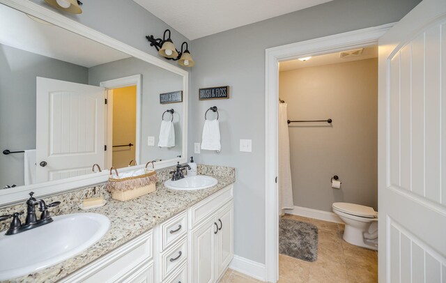 bathroom with tile patterned flooring, vanity, and toilet