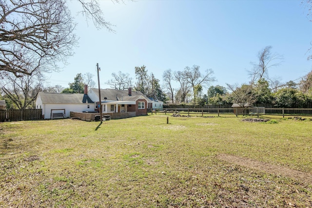 view of yard with an attached garage and a fenced backyard