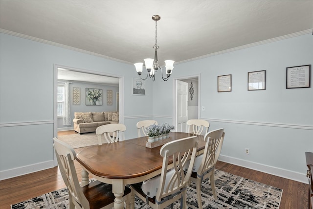 dining area with dark wood finished floors, an inviting chandelier, and ornamental molding