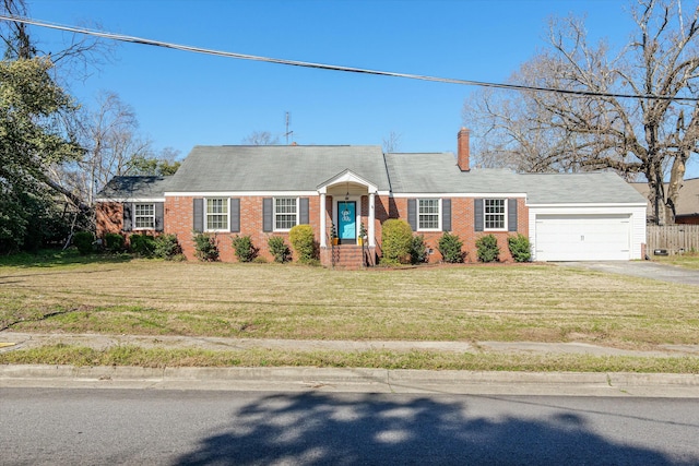 view of front of home featuring driveway, a chimney, a front lawn, a garage, and brick siding