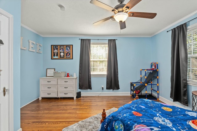 bedroom featuring ornamental molding, a ceiling fan, baseboards, and wood finished floors